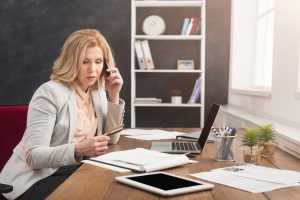 Businesswoman at work talking on phone and shopping online