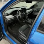 A bright blue Jeep Compass SUV drivers side interior.