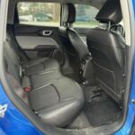 A bright blue Jeep Compass SUV interior view of the back seat with black interior.